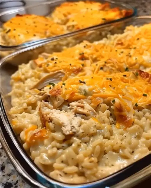 A serving of cheesy chicken spaghetti casserole on a white plate with fresh parsley