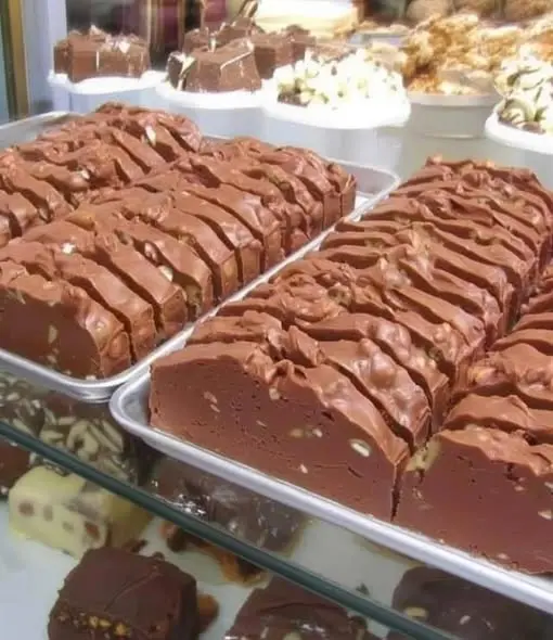 A sliced piece of chocolate eclair cake on a plate showing the beautiful layers