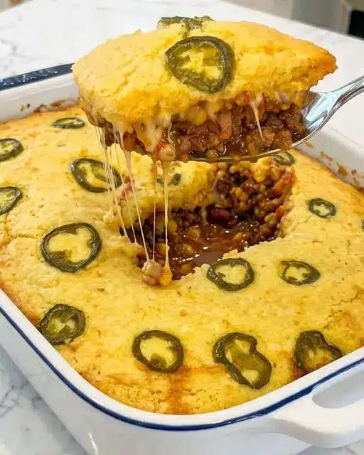 The finished cowboy cornbread casserole served with sour cream and cilantro