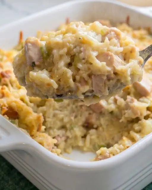 Serving of creamy chicken and rice casserole on a plate with a side of green beans