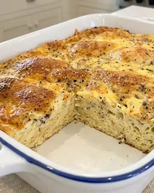 Sliced easy crescent roll breakfast casserole served on a white plate showing layers of egg, sausage, and flaky crust.