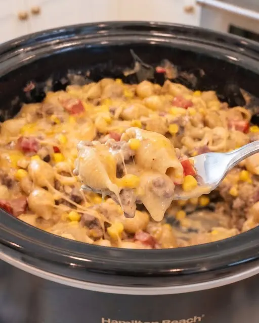 Finished slow cooker taco pasta garnished with fresh cilantro and sour cream