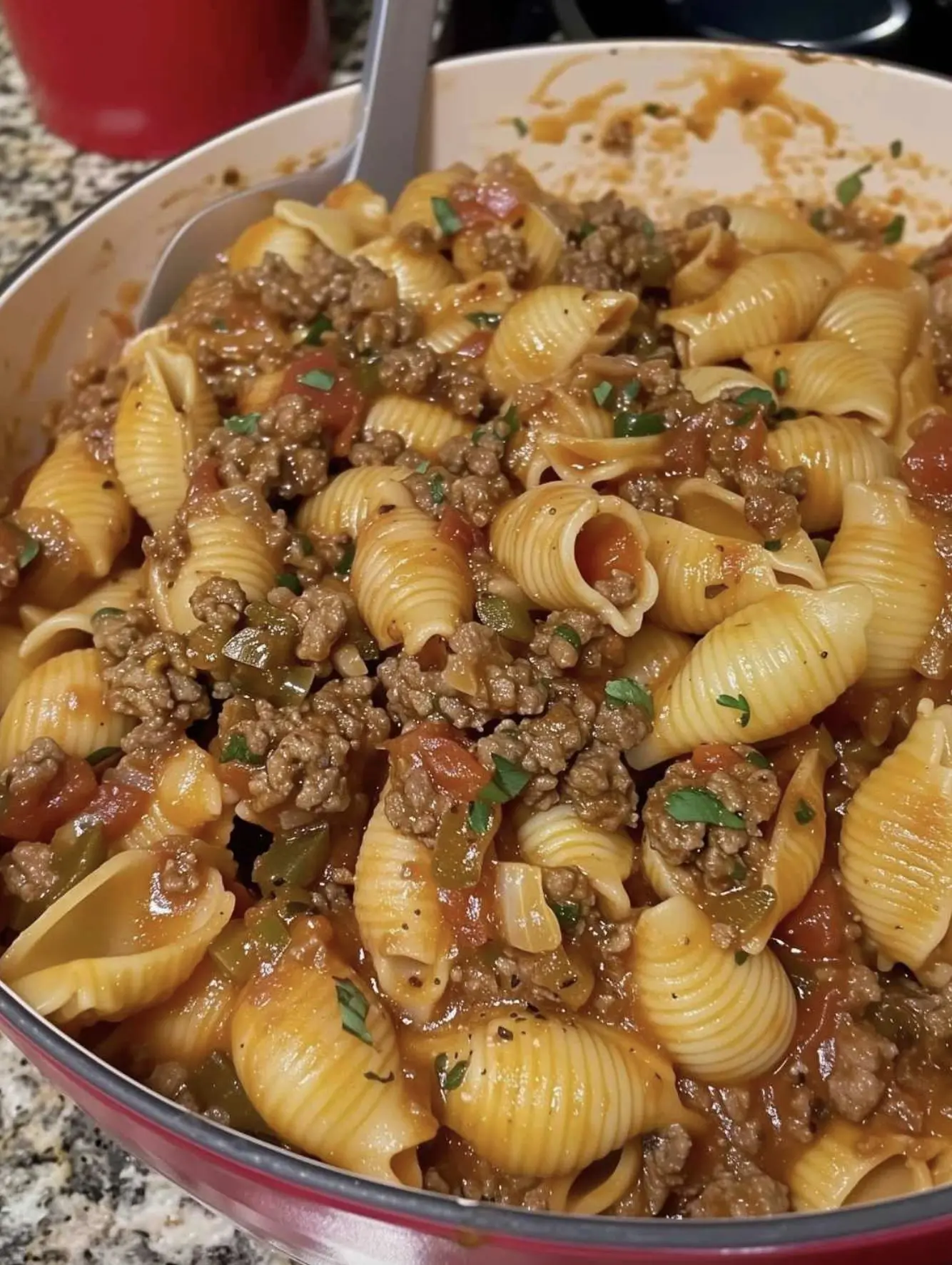Finished creamy ground beef pasta shells served in a bowl with melted cheese