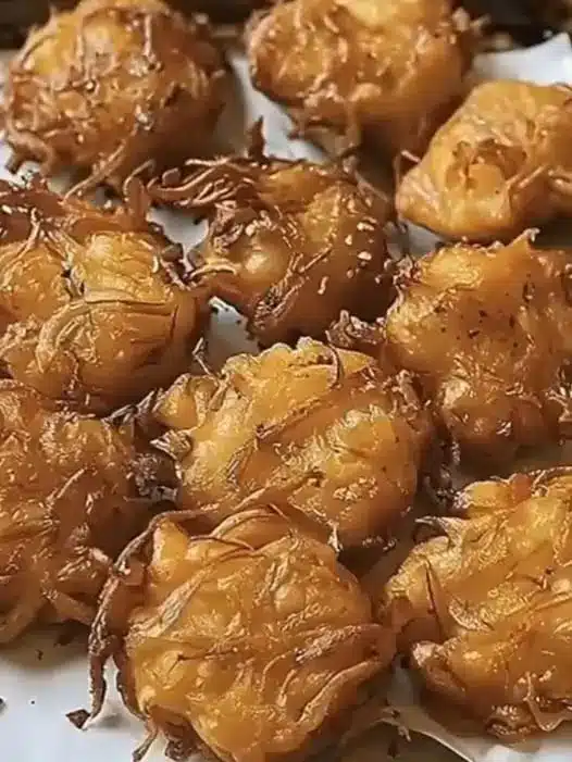A stack of finished coconut macaroons with golden edges