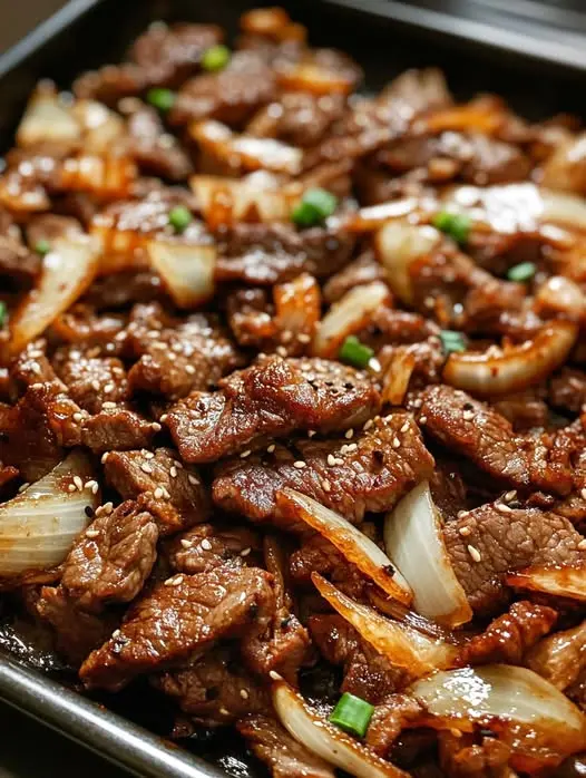 Finished Mongolian beef served over white rice with green onion garnish