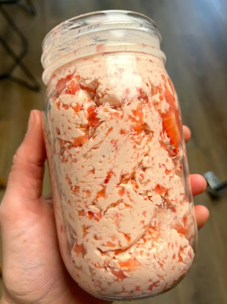 Strawberry butter spread onto a golden brown biscuit with fresh berries