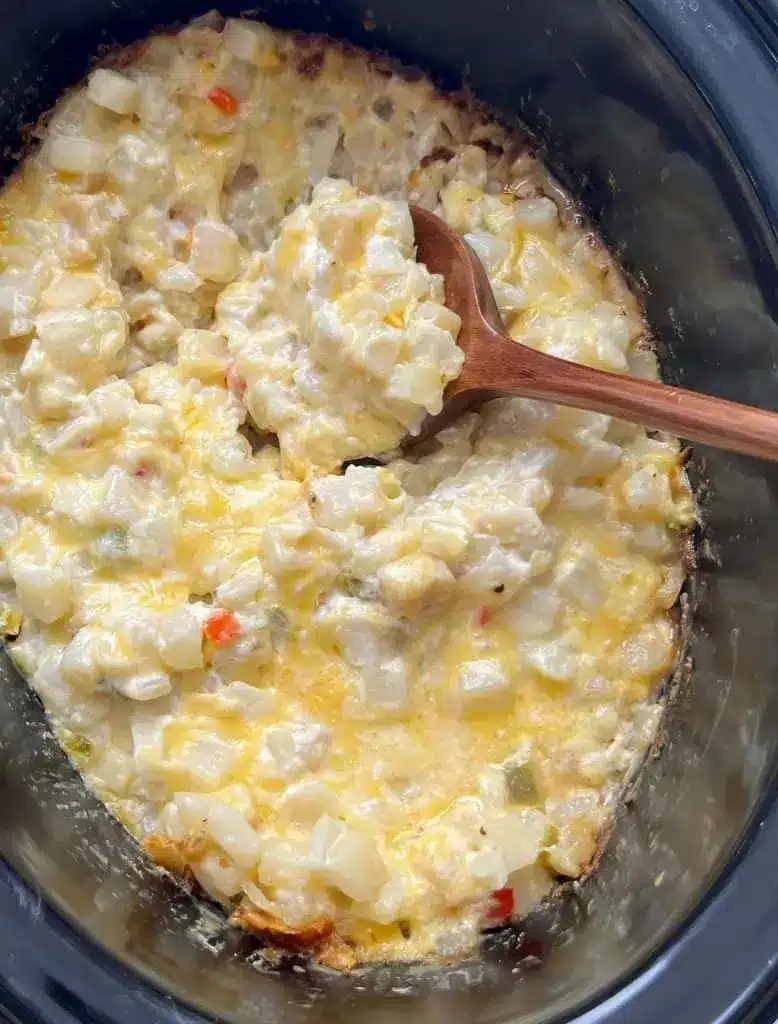 A serving of cheesy Kentucky potatoes on a plate with garnish.
