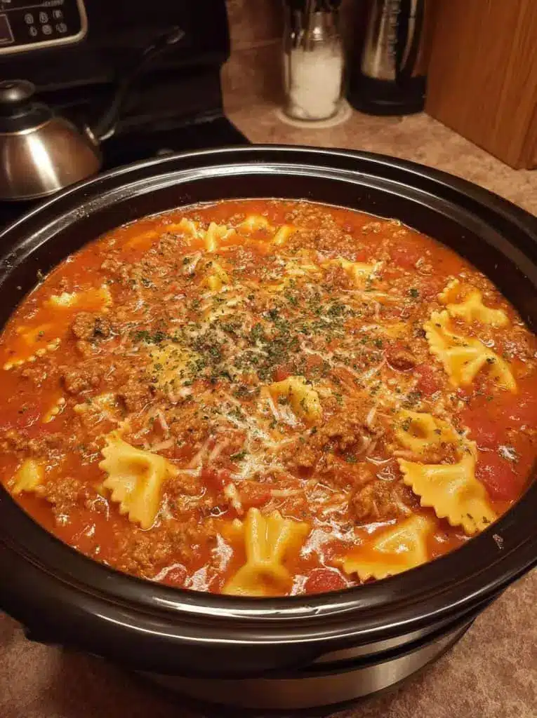 Individual bowl of lasagna soup garnished with fresh basil and a side of garlic bread.
