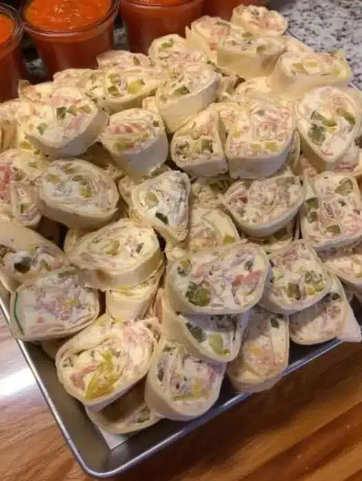 A close-up shot of a single tortilla pinwheel showing the spiral layers of meat and cheese.