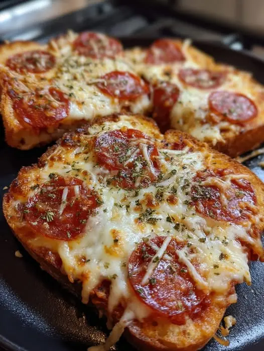 Four slices of pizza toast arranged on a wooden serving board