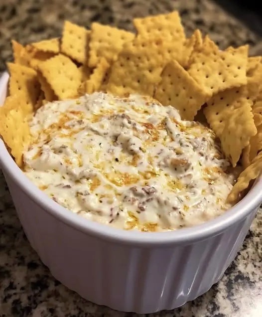 Finished creamy sausage dip in a bowl with tortilla chips for dipping