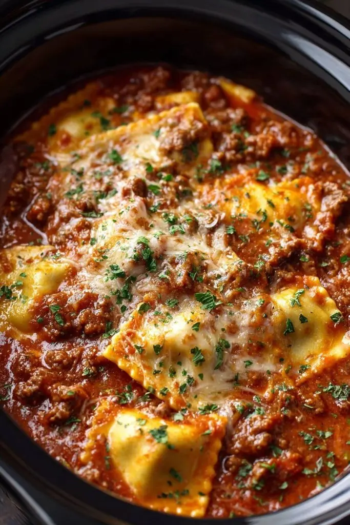 Serving of slow cooker ravioli casserole on a white plate with a side of garlic bread
