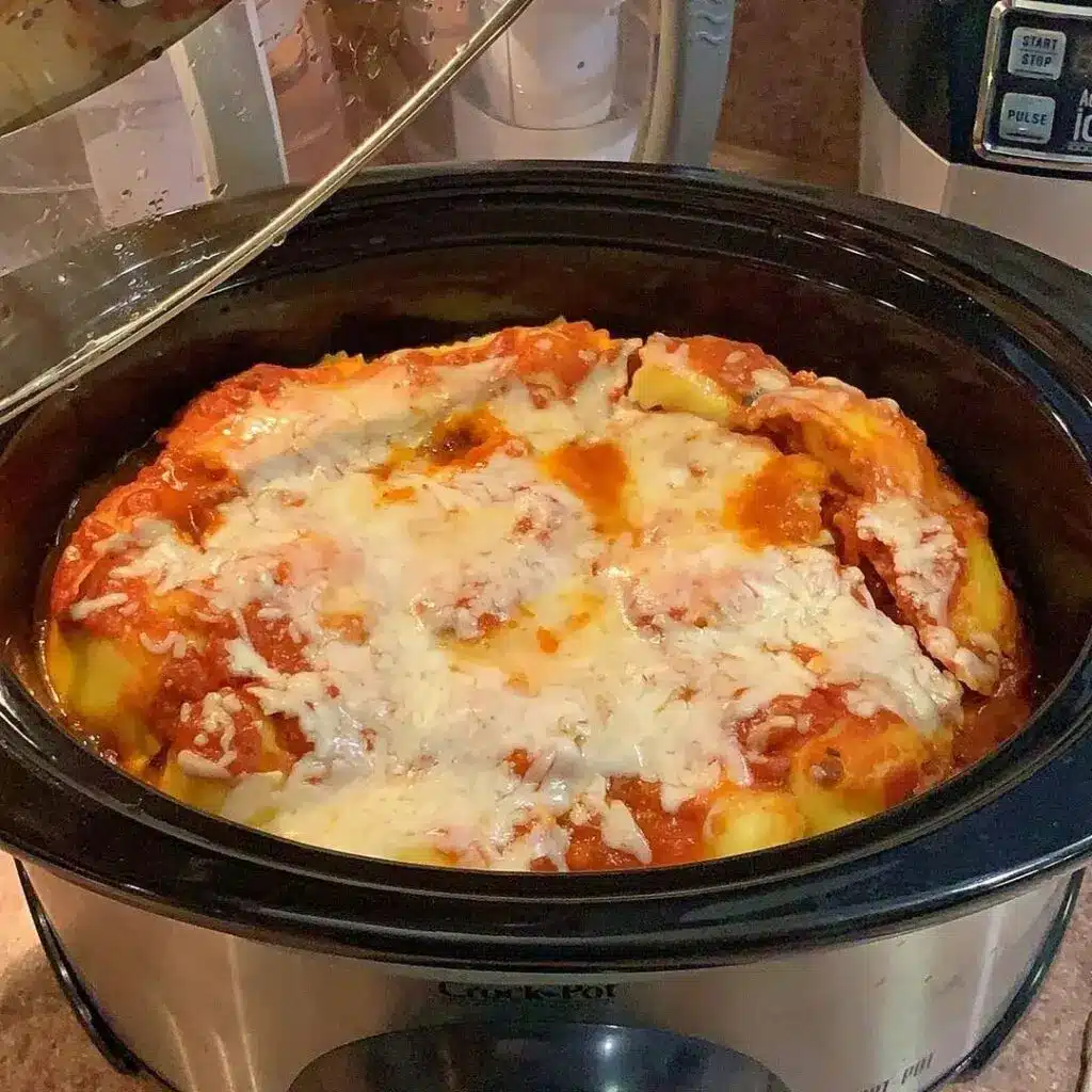 Plated serving of slow cooker ravioli lasagna with melted cheese and fresh basil garnish