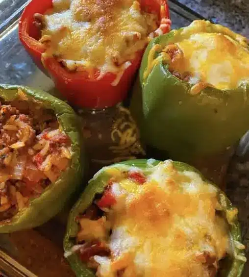 A finished plate of easy stuffed bell peppers topped with melted cheese and fresh herbs