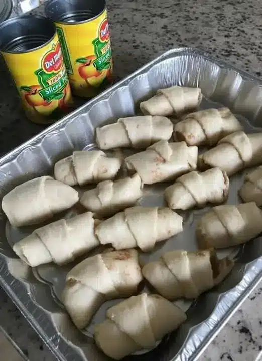 Freshly baked stuffed crescent rolls piled on a serving plate with dipping sauce