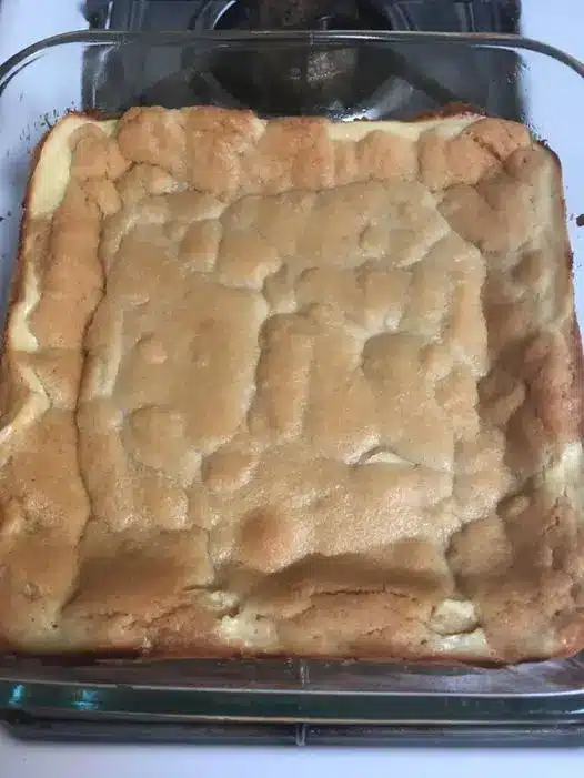 sliced sugar cookie cheesecake bars stacked on a plate showing the layers