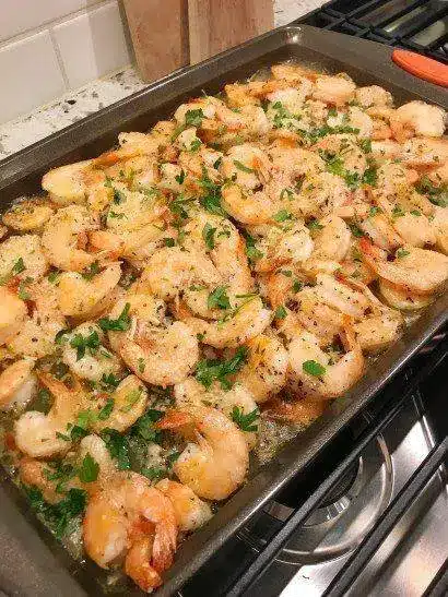 Finished garlic parmesan shrimp served with lemon wedges and parsley