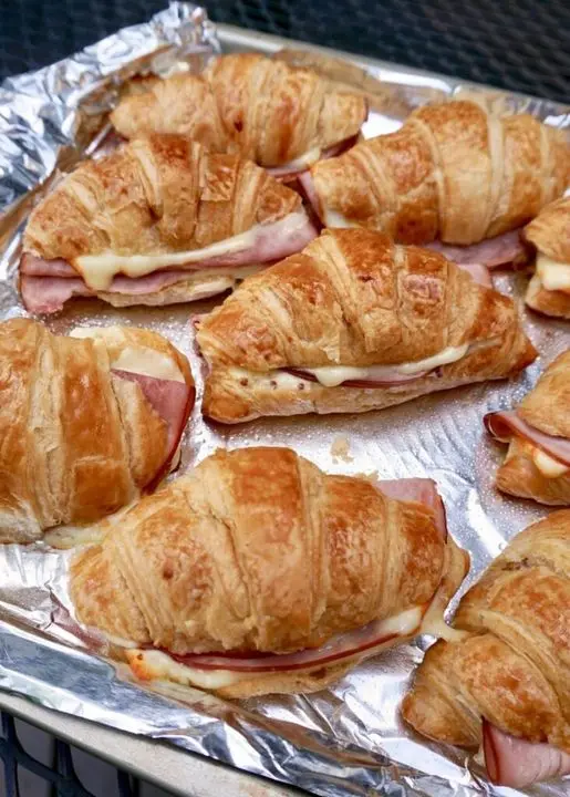 Golden brown Hawaiian ham and cheese sandwich rolls served on a white platter