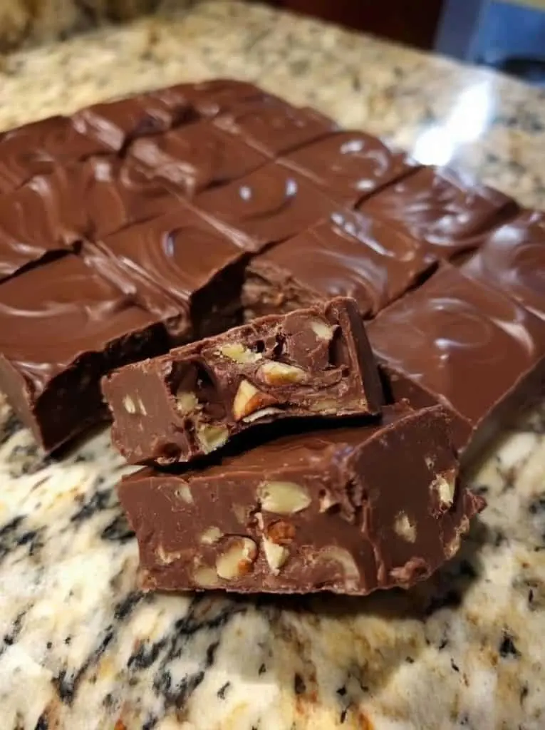 Finished squares of Hershey's old fashioned fudge stacked on a wooden board
