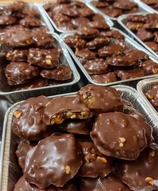 Beautifully arranged homemade chocolate turtle clusters on a serving platter