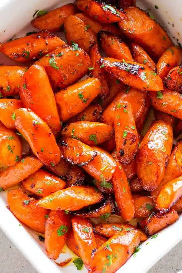 Roasted carrots on a white serving platter with honey butter glaze