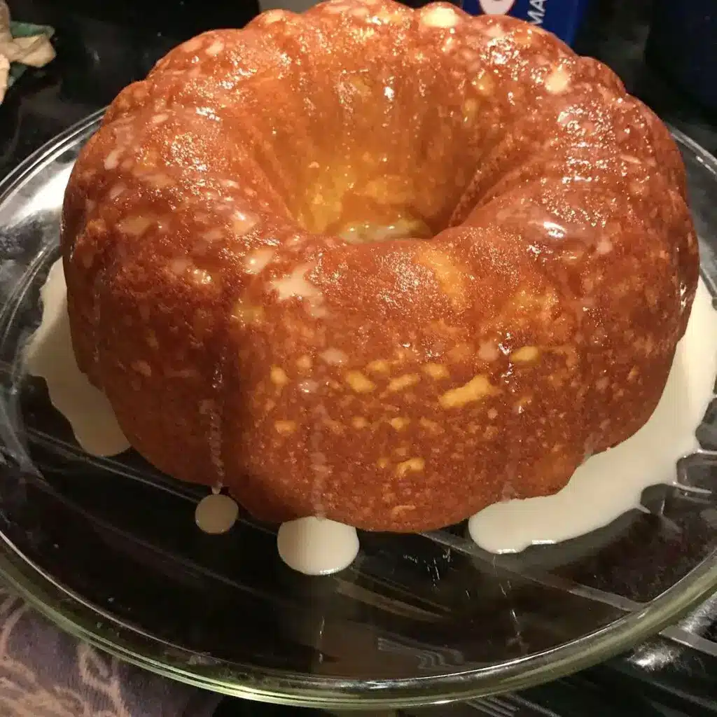 A whole lemon cream cheese pound cake on a white serving platter