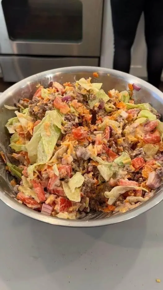 Assembled keto cheeseburger salad bowl with creamy dressing and sesame seeds