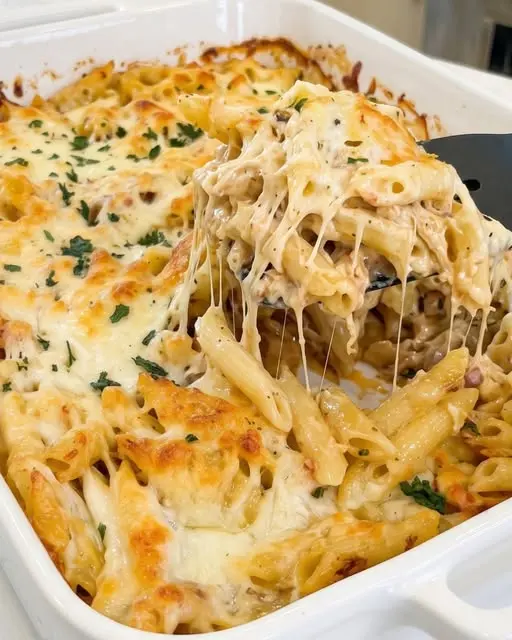 A serving of marry me chicken pasta bake with fresh basil garnish