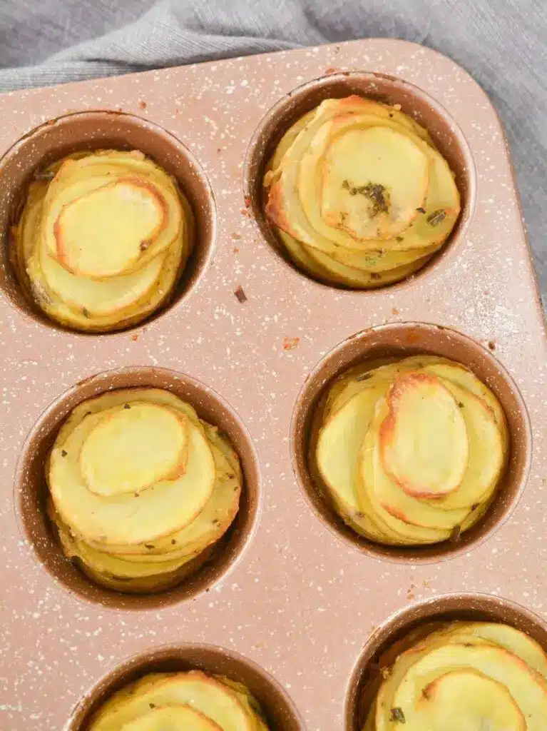 Plated potato stacks garnished with fresh herbs and sea salt