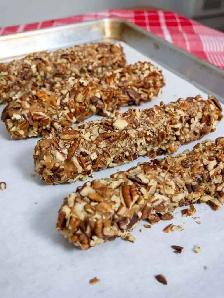 Sliced pecan logs on a serving platter showing the creamy white center