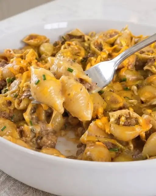The finished one pot creamy beef shells garnished with fresh parsley in a large skillet.