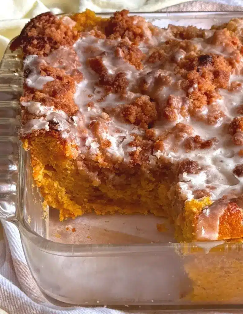 A slice of pumpkin spice crumb cake showing the moist interior and thick crunchy topping.