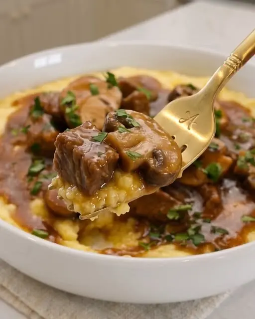 Slow cooker beef tips served over creamy mashed potatoes