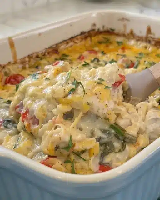 Serving of chicken orzo bake with melted cheese and fresh spinach