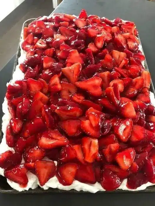 A slice of strawberry cream cheese icebox cake on a white plate with visible layers