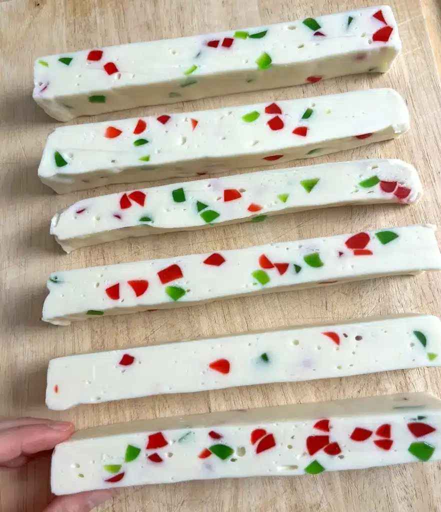 Wrapped Christmas candies in a gift box with festive ribbon