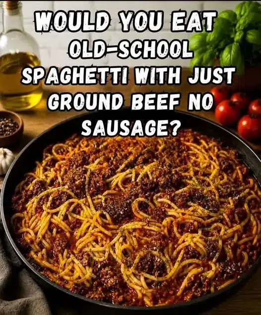 Plated spaghetti with red sauce, garnished with a sprig of basil and a dusting of parmesan cheese.