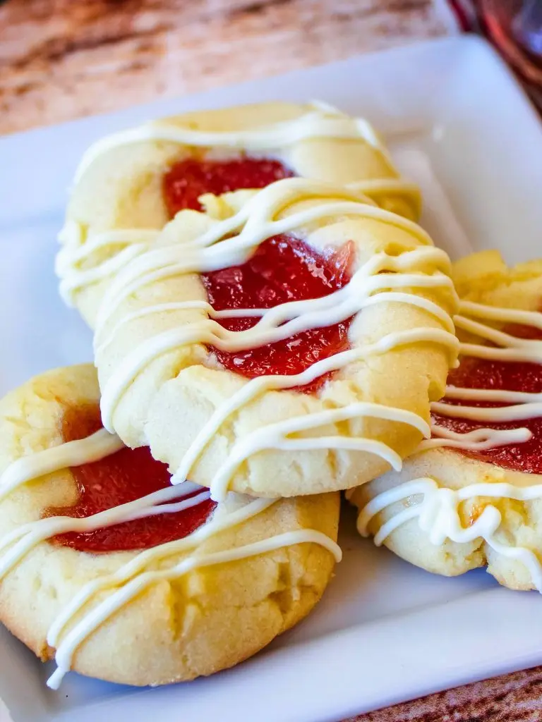 A stack of white chocolate raspberry shortbread cookies showing the white chocolate chunks and red berry flecks